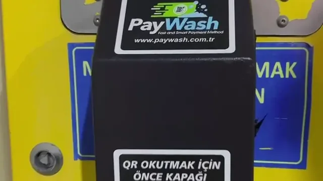 Jetonlu bir yıkama makinesine takılmış PayWash ünitesi