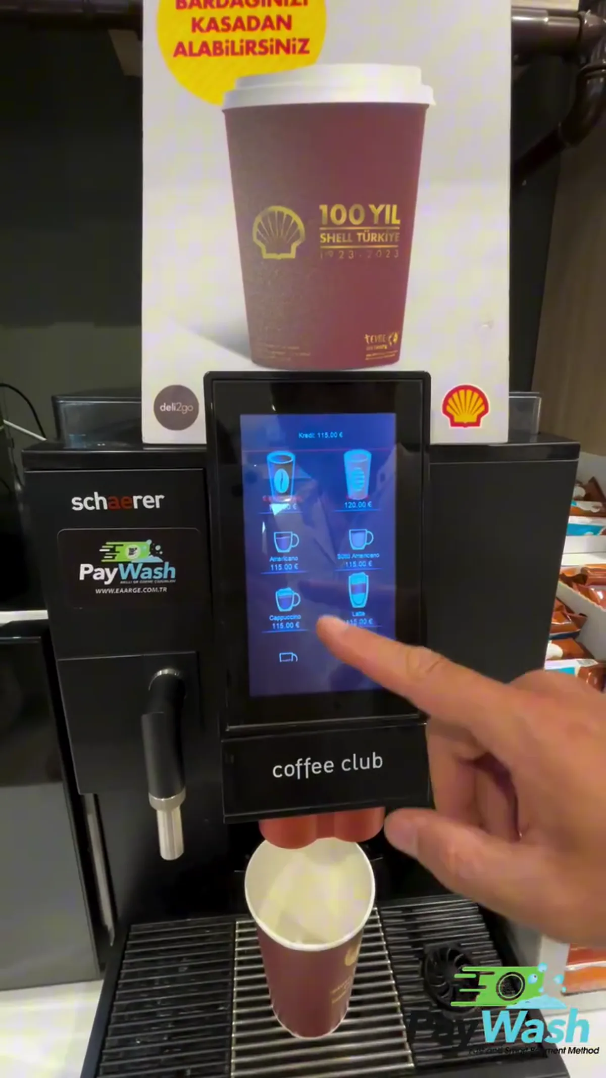 Kahve makinesine takılı PayWash okuyucusu ve ekranda yüklenen kredi